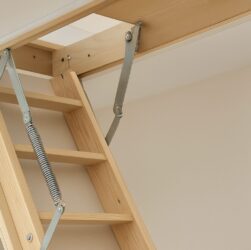 Close-up of a loft ladder mechanism showing steps and springs