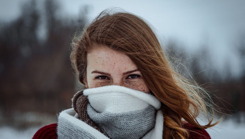 Portrait of a young woman with freckles, wrapped in a wool scarf, against a snowy winter background. — Why Choosing the Right